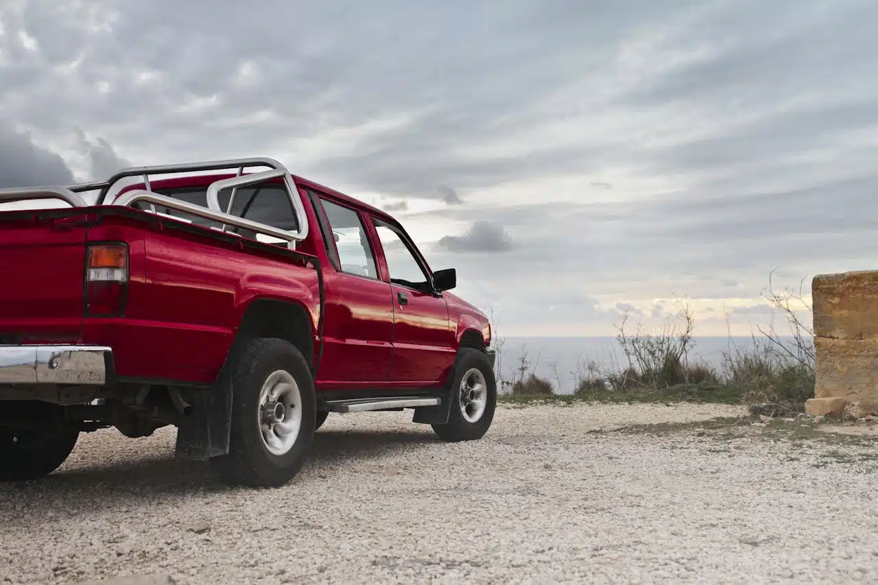 A red pickup truck pictured during daytime.