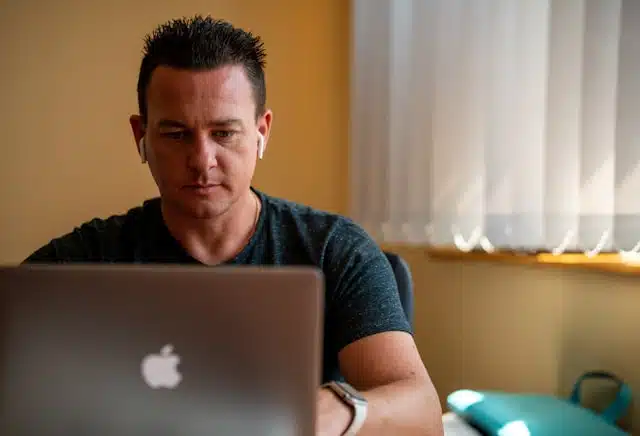 A man applying for a title pawn online from the comfort of his home, using a laptop. 